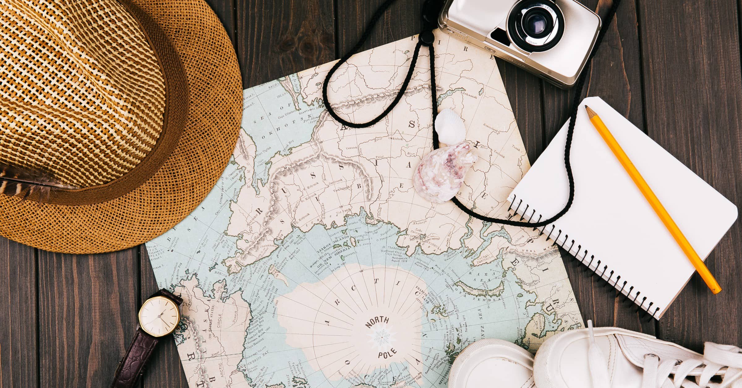 planning for a trip, travel essentials, map, hat, notebook